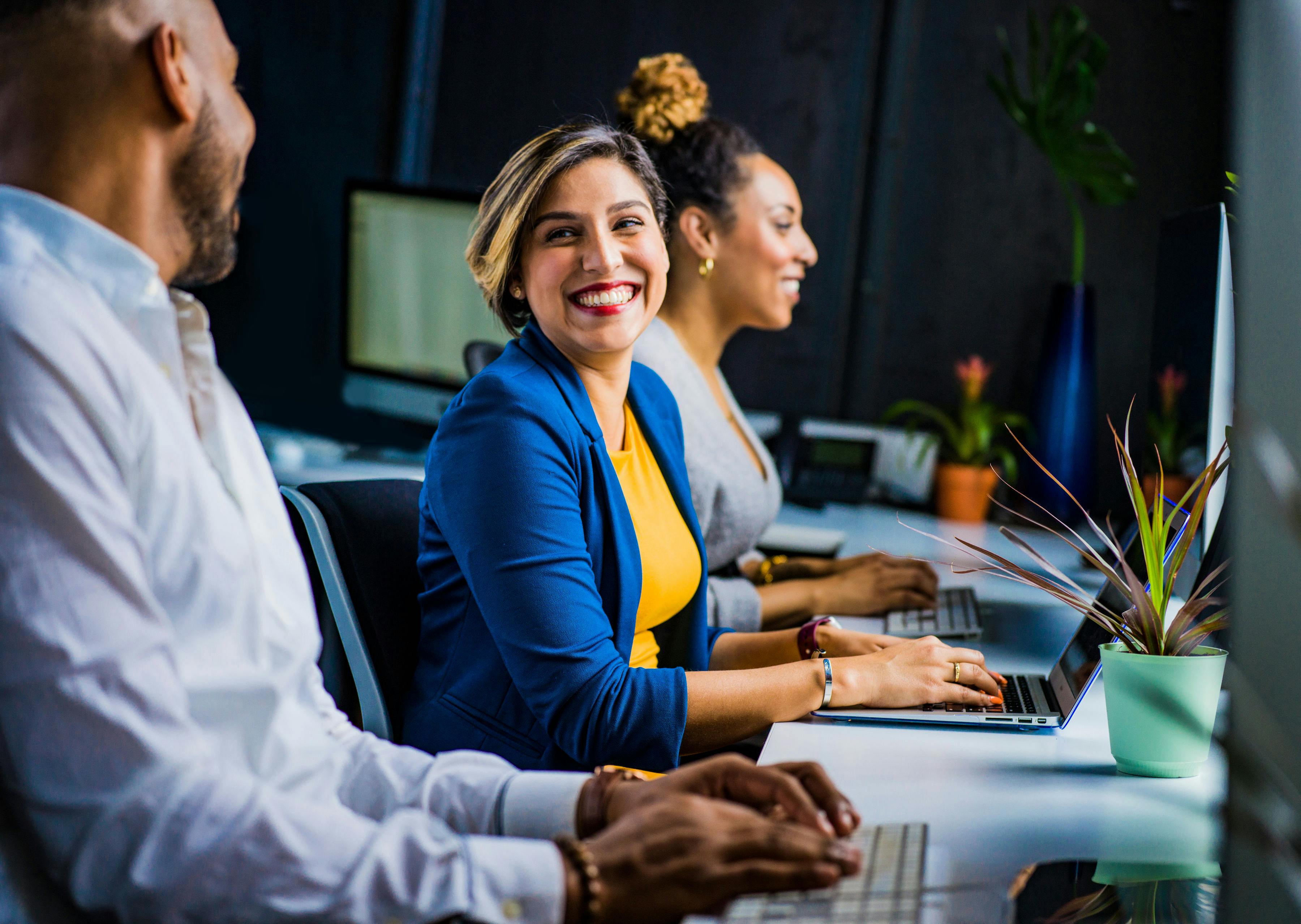 People sitting a t a desk smiling.